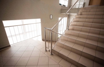 Dlouhé schodiště s mezipatry na chodbě bytovky